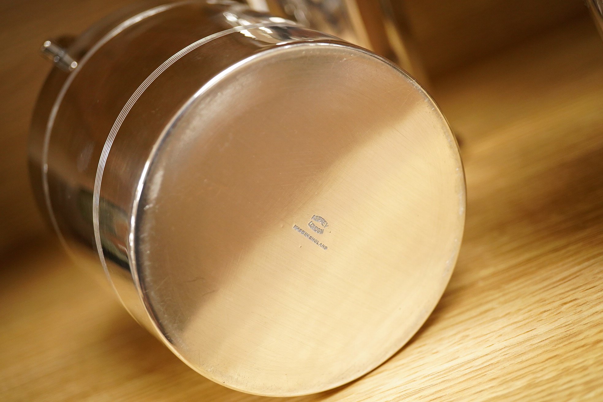 A mid 20th century silver plated patent cocktail shaker with recipes, two other cocktail shakers and an ice bucket, largest 28cm high